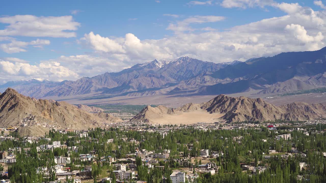 Panoramabillede af landskabet i de øvre Himalaya med skyer og Leh by i Ladakh, Indien