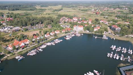 mikolajki, poland - aerial bird view flight flyover the harbor of the touristic city in warmian masurian with tiny passenger ships and expensive yachts on a beautiful calm lake in summer