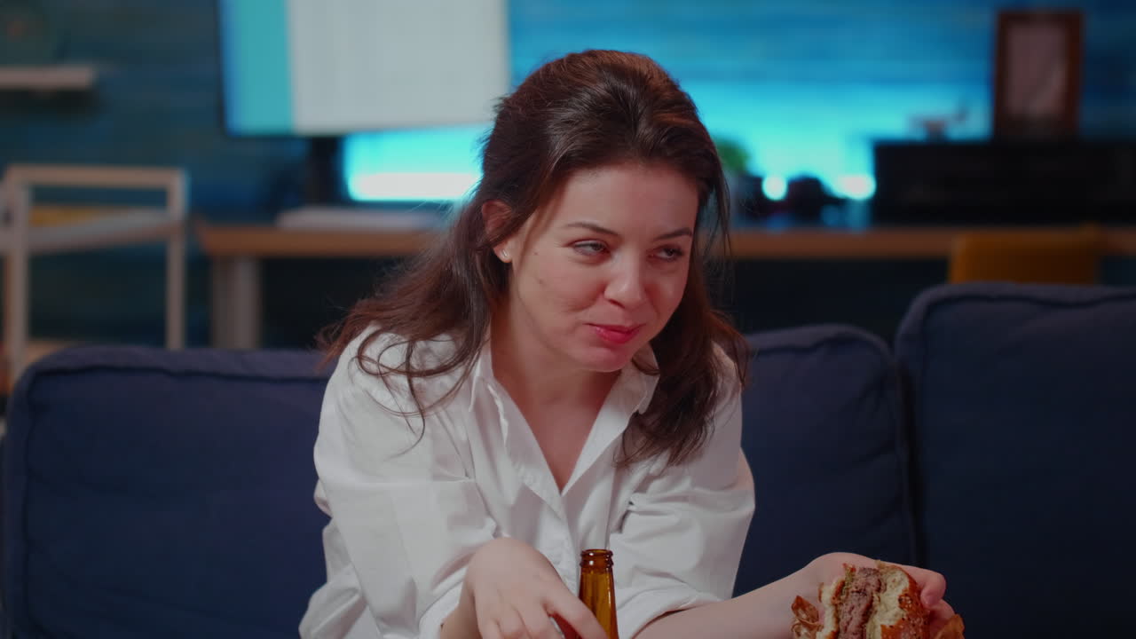 Young person with fast food meal watching television