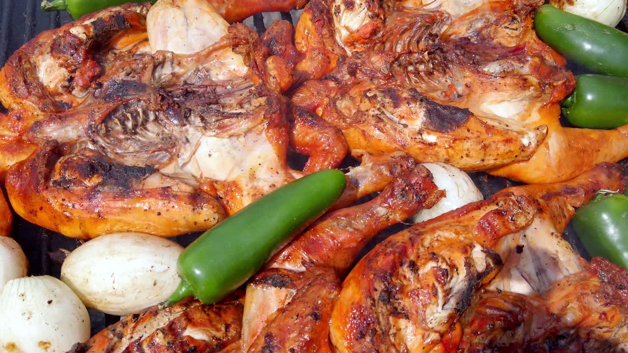 Grilled chicken with peppers and onions sizzling on the barbecue grill