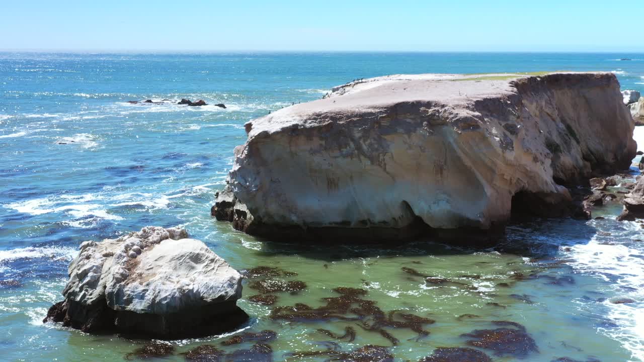 suaves olas del océano que se hinchan a lo largo de una costa rocosa en el sur de california en un día soleado