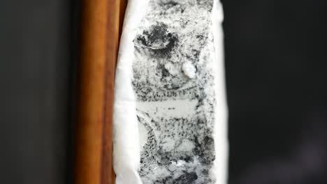 close-up of a round wheel of ash-covered cheese