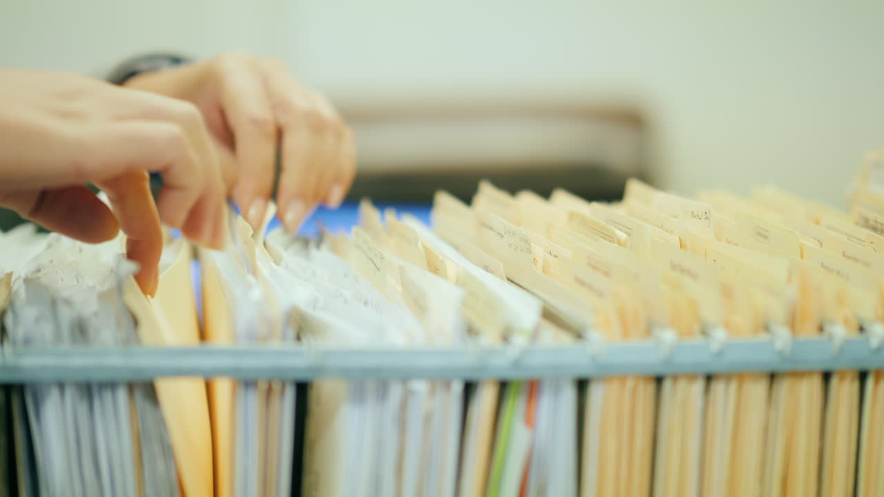 서류 캐비넷 서랍을 손으로 분류하다