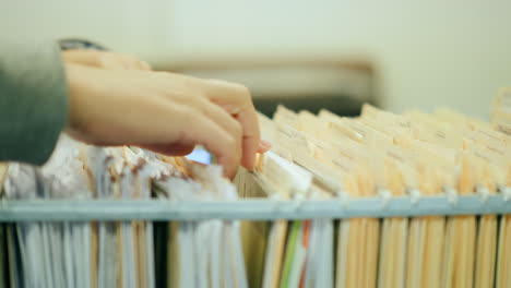 Hands Sort Through Filing Cabinet Drawer