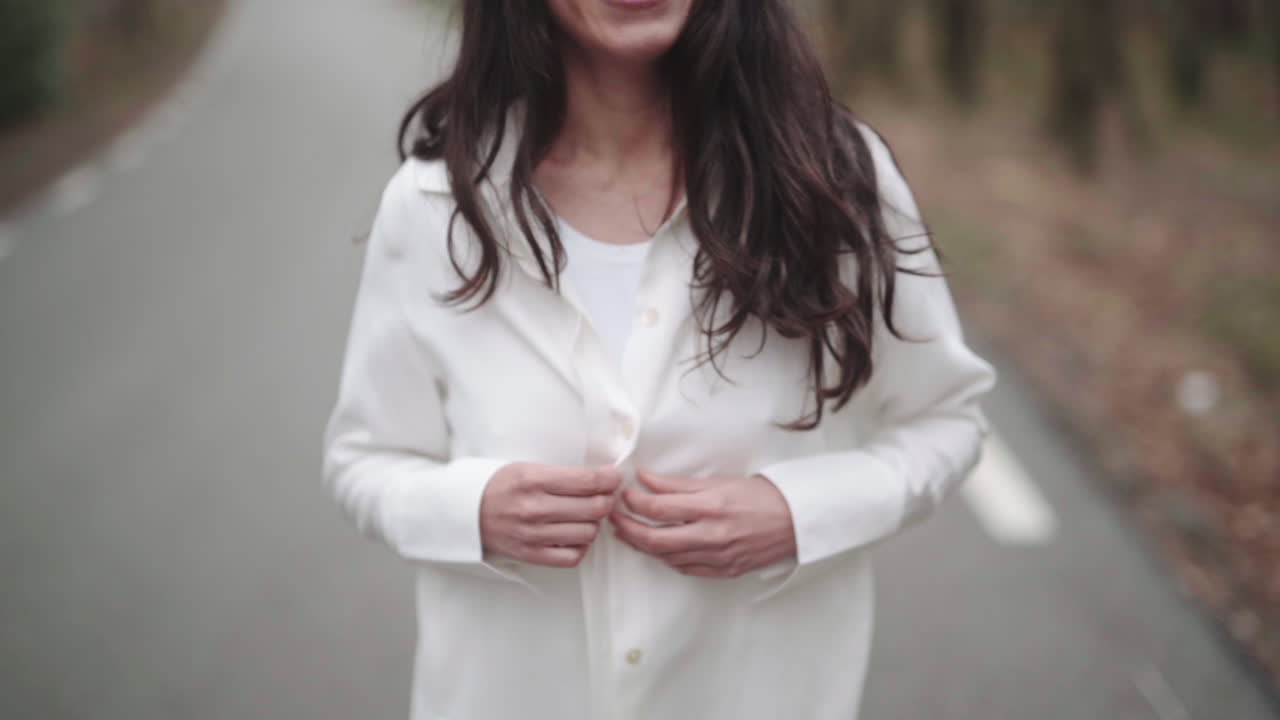 latino abotonándose la camisa blanca juguetonamente lentamente