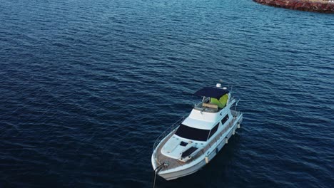 Flying-over-a-luxury-motor-yacht-and-towards-a-modern-boutique,-Red-Sea-beach-resort-in-Eilat-Israel-in-golden-light