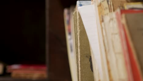 Close-up-of-a-bookshelf-as-a-person-reaches-in-to-take-and-book-and-put-one-back-on-the-shelf