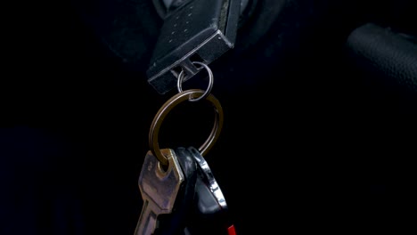 slow motion close-up of hand reaching for swinging car keys in ignition engine start vehicle safety security transport starting driving keyring sensor