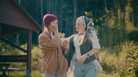 female friends walking together in forest during vacation