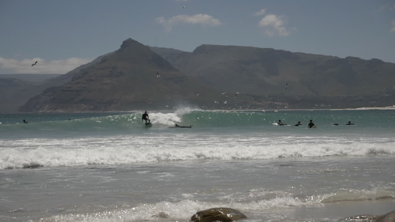 Slowmotion av surfare längs kusten i Sydafrika.