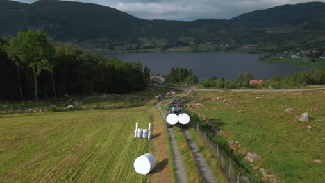 plastic wrapped bales being transported with tractor in hjelmeland, norway