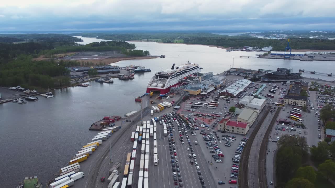 Cruise ferry and bunch of cars and trucks at the harbour on a cloudy day. Drone shot