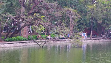 people walking along a scenic pond path