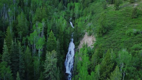 Revelador-Disparo-De-Vuelo-Sobre-Una-Cascada-Con-Agua-Blanca-Embravecida-Corriendo-Sobre-Las-Rocas-Durante-La-Escorrentía-De-Primavera