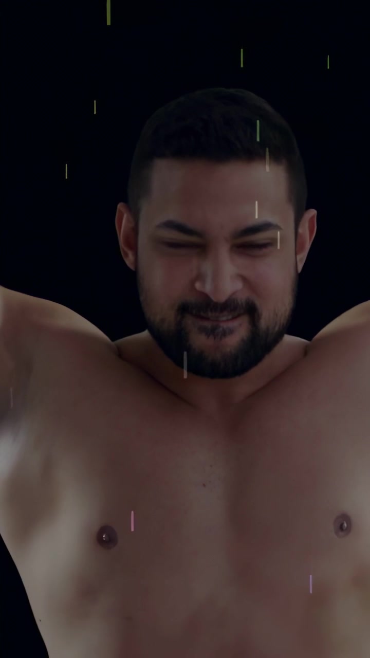 Video verticale: Modello uomo che reagisce a stelle fluttuanti su sfondo nero, flettendo il petto per il fitness.
