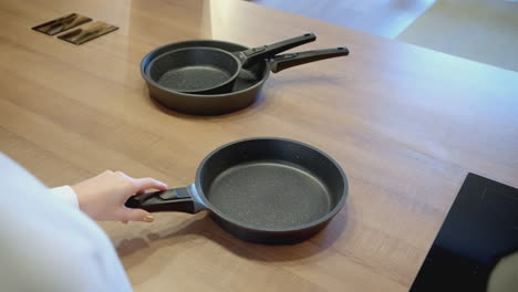 woman holding a frying pan on a kitchen counter