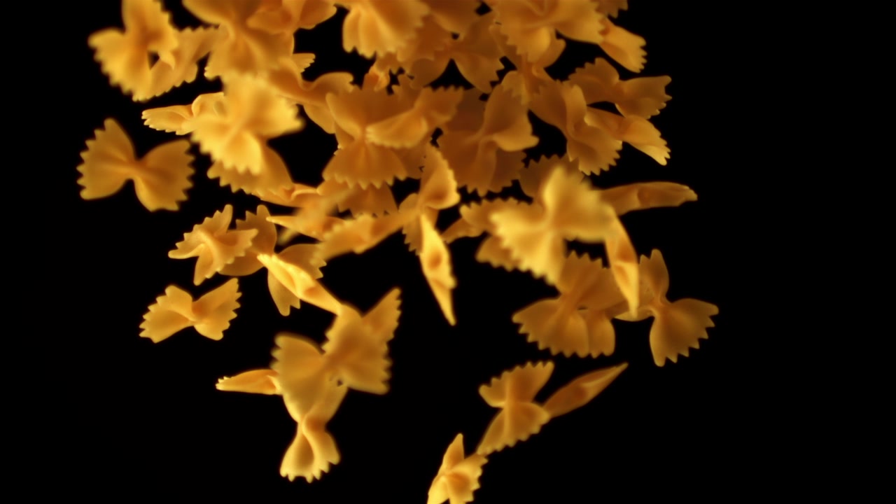 Pasta farfalle cruda messa a fuoco su sfondo nero