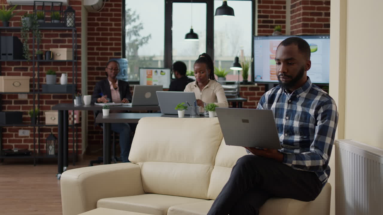 African american man using laptop to create financial statistics