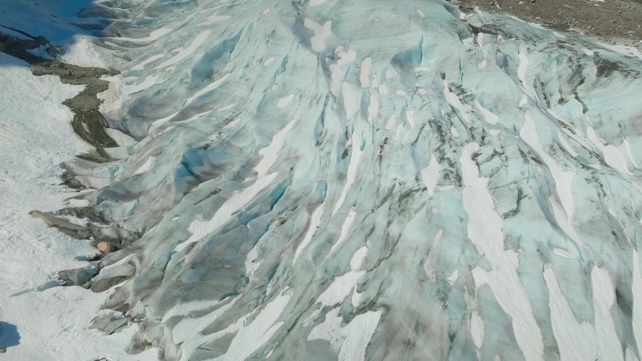 Filmato drone aereo dall'alto che rivela intricate texture di ghiaccio glaciale e motivi astratti congelati in un vasto paesaggio ghiacciato, perfetto per immagini di natura e clima.