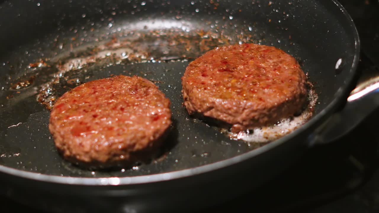 Static Medium Shot of Burgers Cooking Getting Ready to Serve in Buns. Beef Patties Food Footage 4K.