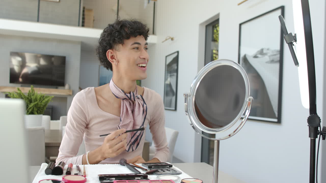 Applying makeup, non binary person smiling and using mirror in modern home setting