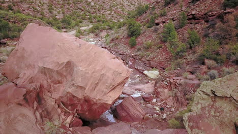 Slow-flight-over-boulders-and-red-rocks-in-canyon