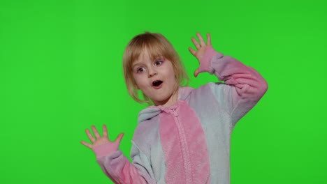 Child-girl-in-unicorn-pajamas-making-silly-funny-faces,-fooling-around,-showing-tongue-on-chroma-key