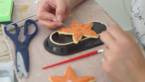 imágenes de una mujer caucásica haciendo galletas de estrellas de mar