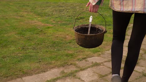 Slow-motion-camera-shot-from-the-back-of-the-woman,-which-is-walking-in-the-countryside-farm-to-feed-their-dogs