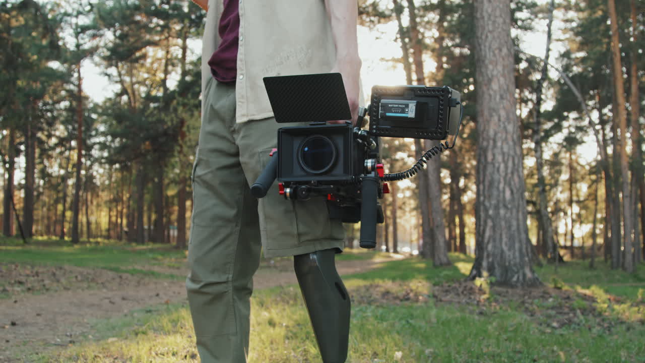 Man With Prosthetic Leg Holding Video Camera Standing Outdoors
