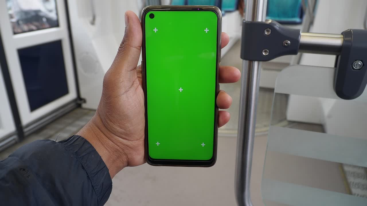 persona con un teléfono de pantalla verde en el transporte público