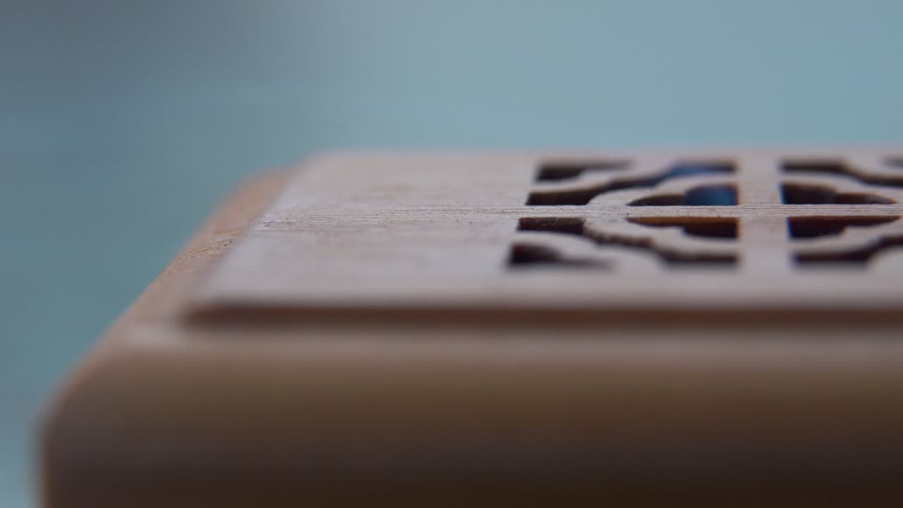 A macro shot of smoking incense in a wooden box, spiritual ritual meditation, scented therapy fragrance, relaxing aromatic white smoke, cinematic 4K video pan right