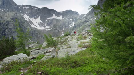 un joven está haciendo senderismo en los alpes italianos durante un día nublado