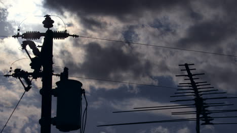 tilting time lapse of sun going down behind roof antennas and power lines