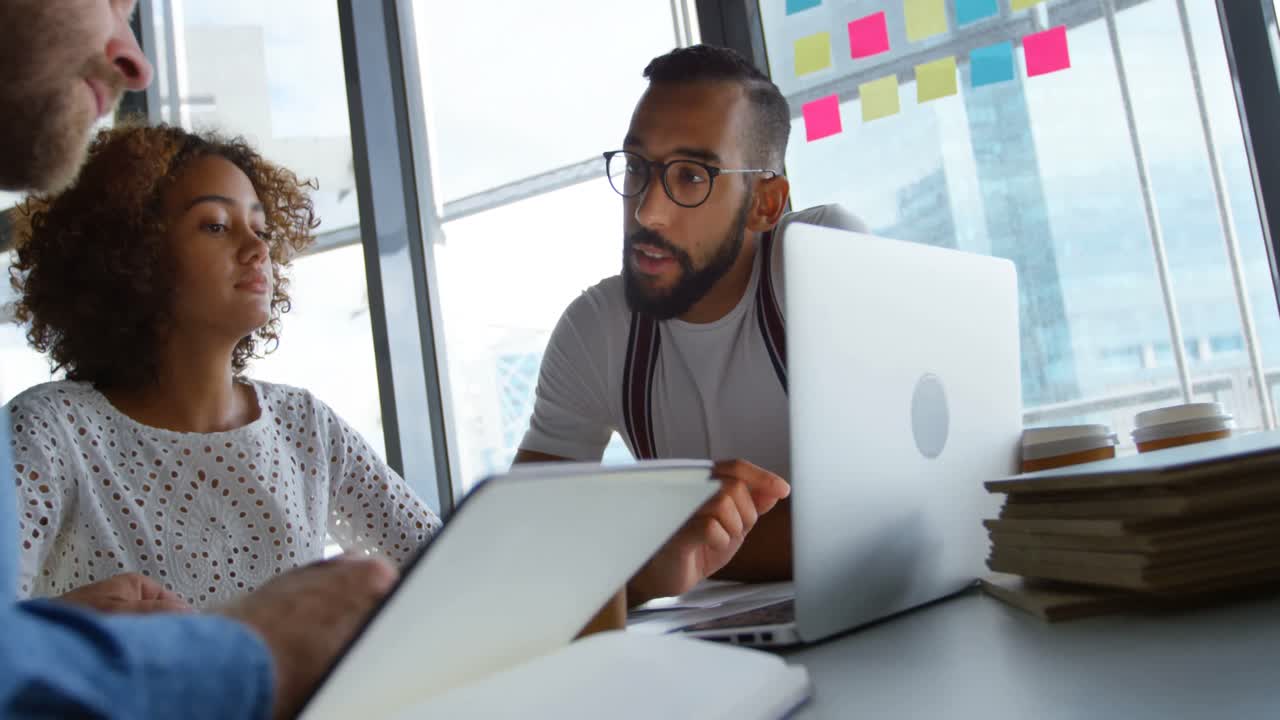 Business colleagues discussing over laptop 4k