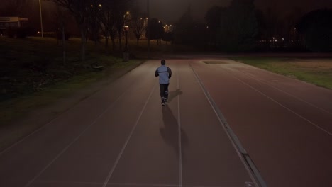 tracking shot of athletic person jogging on track at evening time