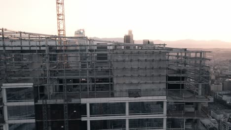 A-young-adult-male-stands-on-a-skyscraper-in-Downtown-Los-Angeles-at-sunrise-2