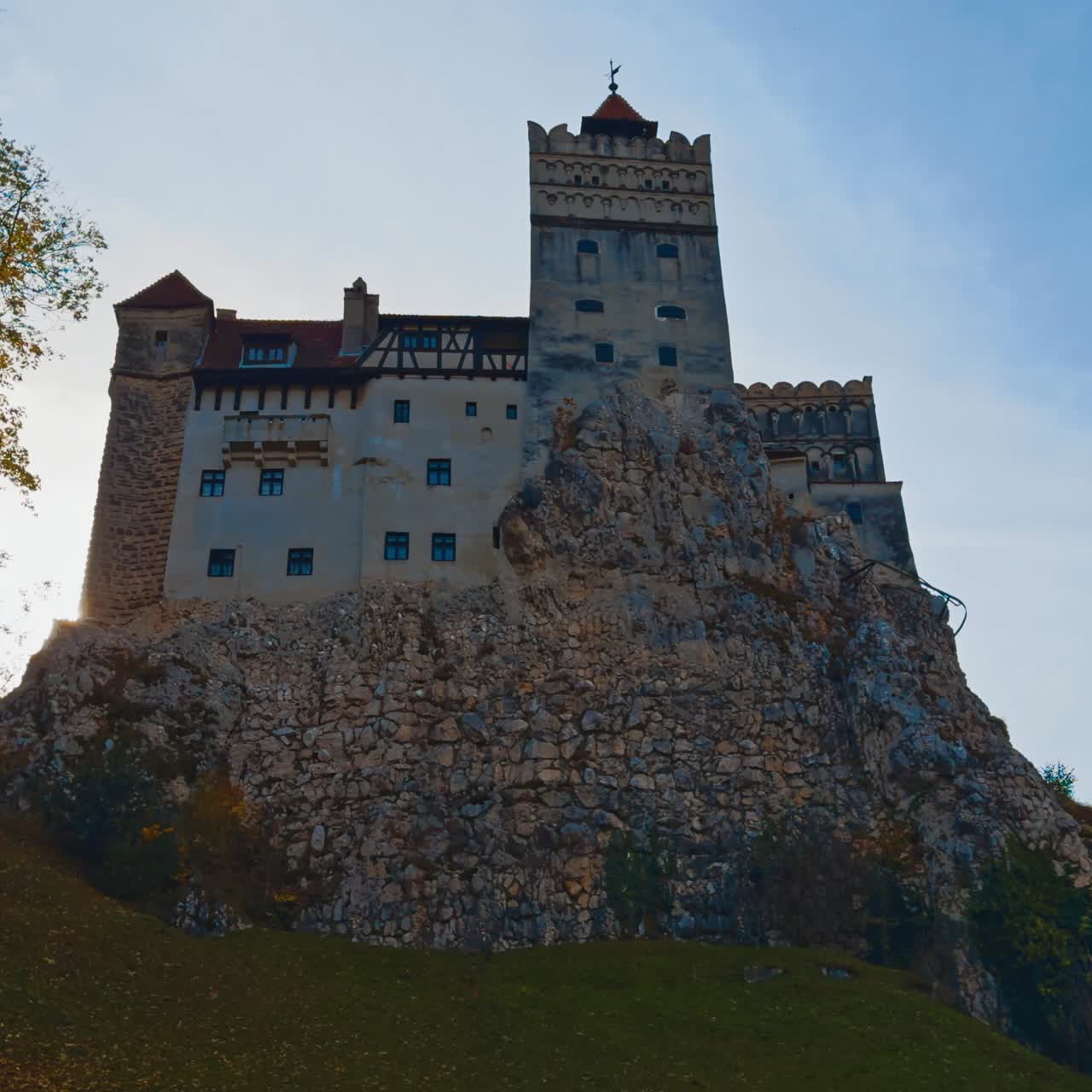 Das wunderschöne Schloss Bran, die Heimstätte des berüchtigten Grafen Dracula. Blick aus niedrigem Winkel auf das historische Gebäude in herbstlicher Natur