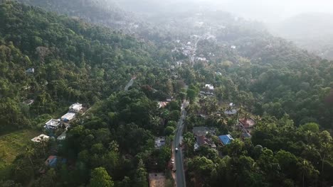 aerial of small road in the mountains in munnar surrounded by houses