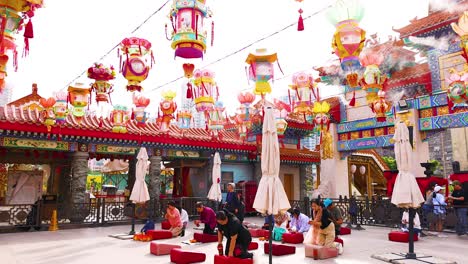 colorful temple scene with people and lanterns