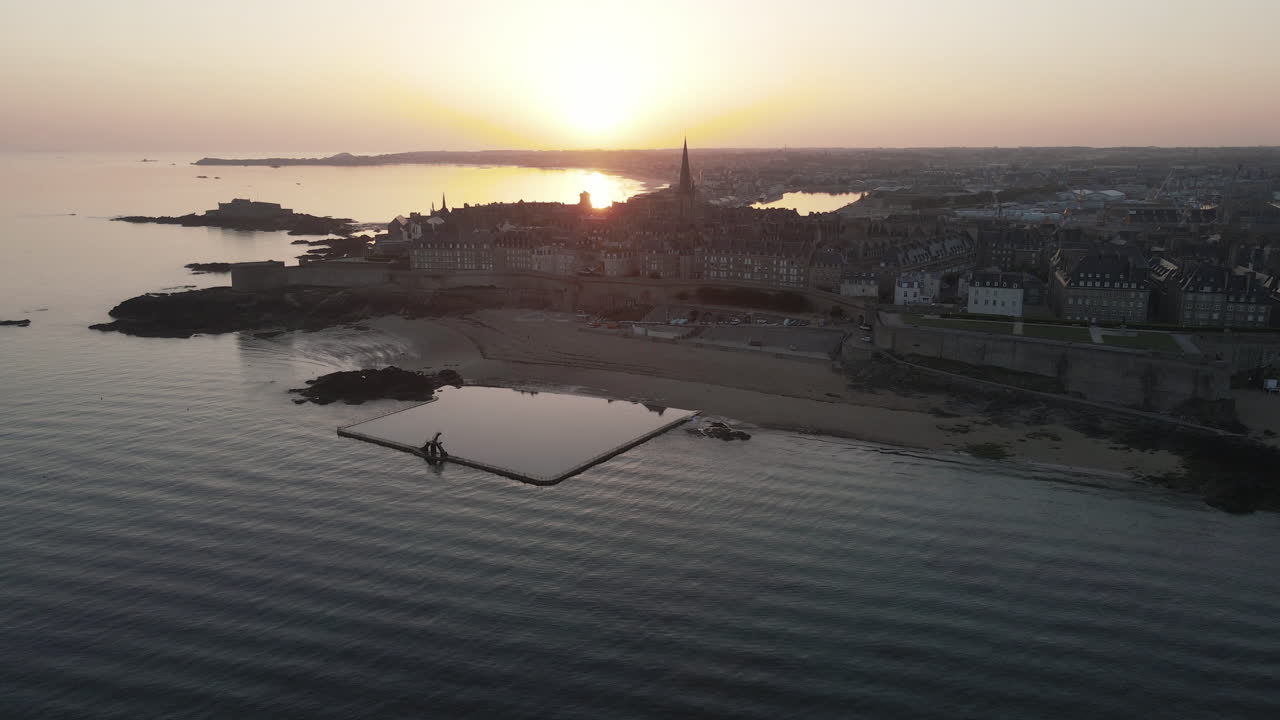 Piscina di acqua salata sulla spiaggia al tramonto con la città vecchia di Saint-Malo sullo sfondo, Plage de Bon Secours, Francia