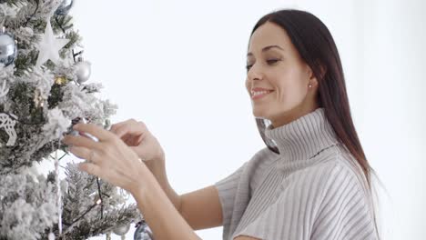 mujer elegante admirando un árbol de navidad