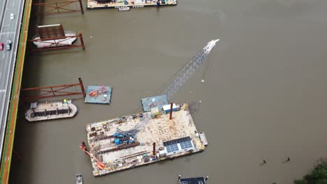 4k aerial view of a new bridge construction site over a river in australia