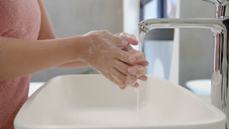 washing hands with soap, young woman enjoying spa treatment at sink