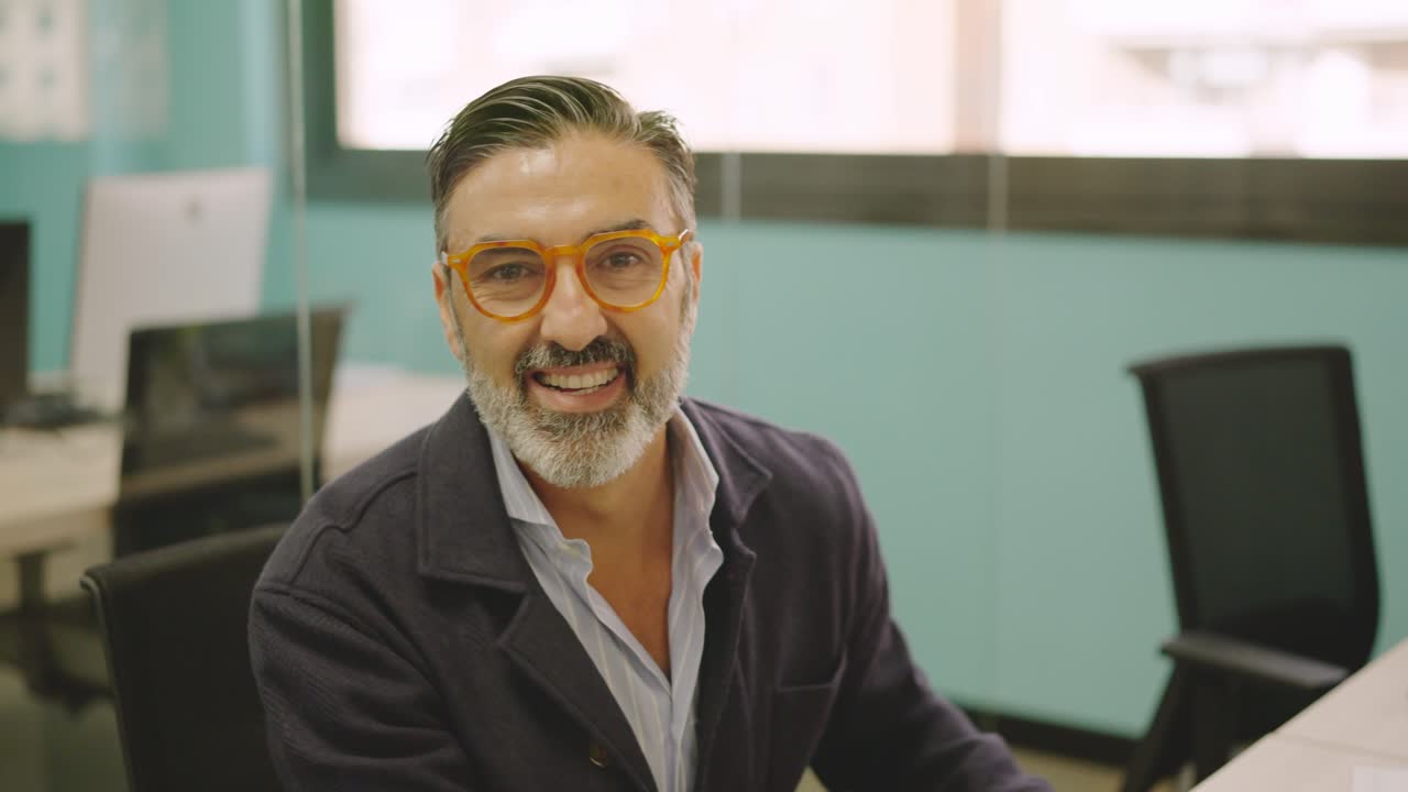 Mature man working in a coworking desk and smiling