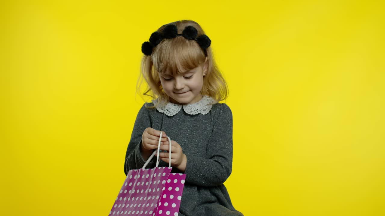 niña con bolsas de compras que muestran la inscripción de black friday, satisfecha con los bajos precios y descuentos