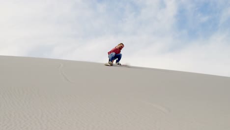 Mann-Beim-Sandboarden-Am-Hang-In-Der-Wüste-4k