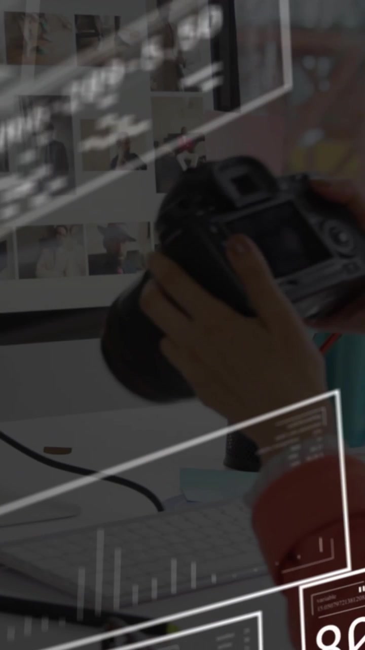 Video vertical: Mujer alcanzando una cámara DSLR en un escritorio creativo, revisando mientras paneles HUD guían la toma