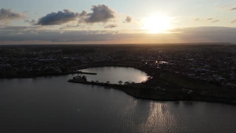 aerial view of a sunset over an urban landscape with a waterbody reflecting the fading sunlight in federacion, entre ríos, argentina
