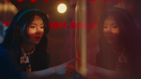 girl looking at reflection in a mirror at a night party